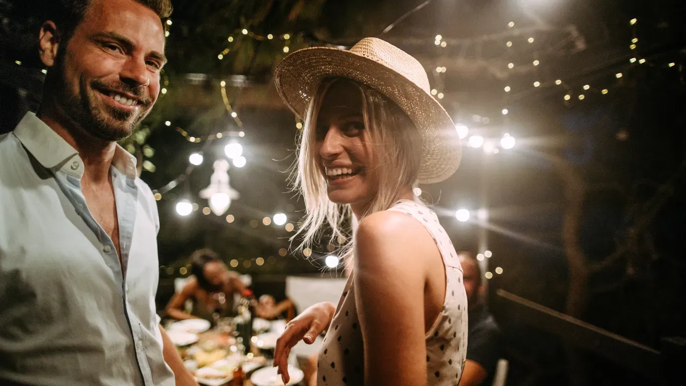 Guests laughing together at a Birmingham DEIGHT dinner under string lights